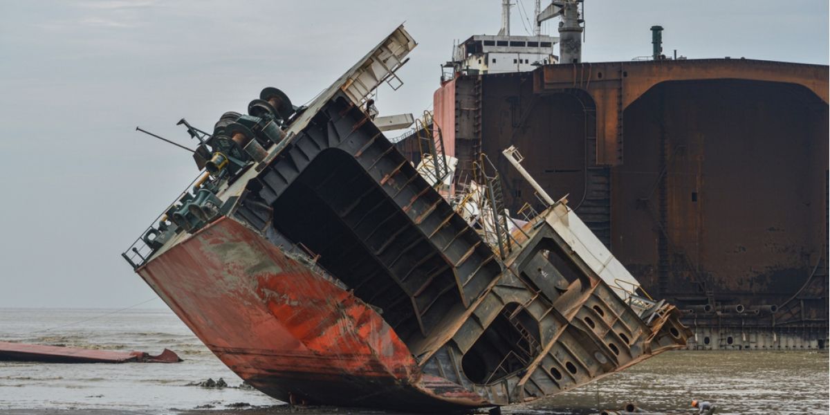 Ship recycling scene showing a dismantled vessel section at a maritime scrapyard